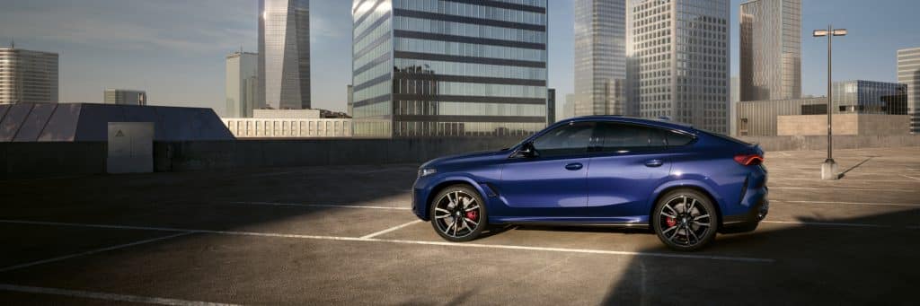 BM X6 blau Seitenansicht auf Parkplatz vor Hochhaus
