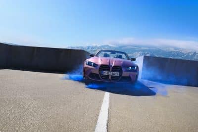 BMW M4 Cabrio Frontansicht auf Parkplatz in blauem Rauch vor Bergen