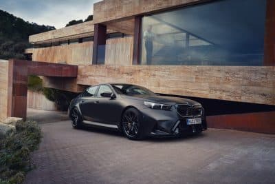 BMW M5 Limousine schwarz vor Holzgebäude