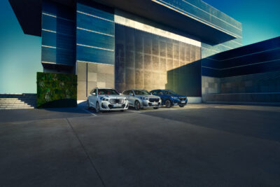 BMW X1 Range in weiß, silber und blau vor modernem Haus