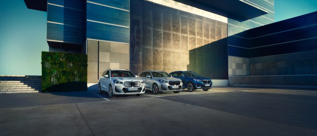 BMW X1 Range in weiß, silber und blau vor modernem Haus