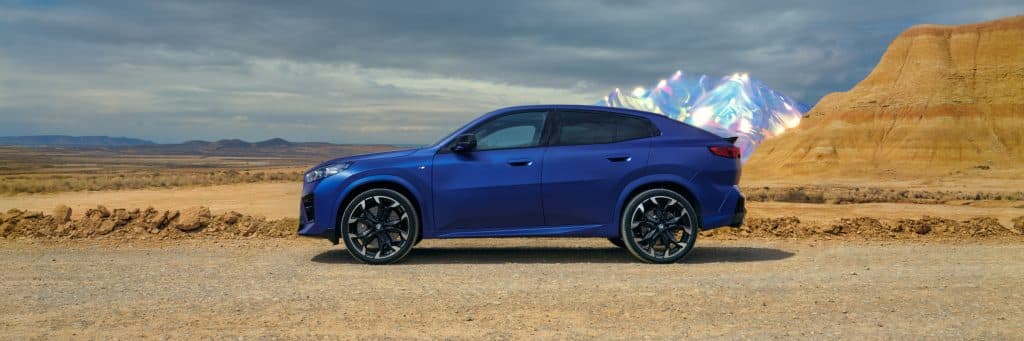BMW X2 blau Seitenansicht vor wüstenartiger Landschaft