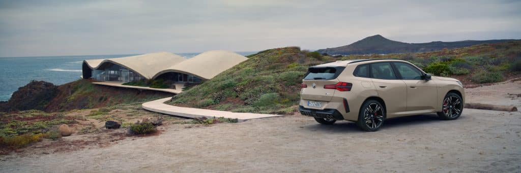 BMW X3 an Küste vor modernem Gebäude