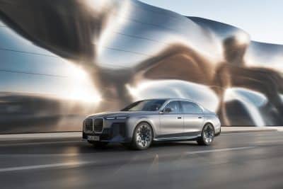 BMW i7 silber Seitenansicht vor futuristischem Hintergrund