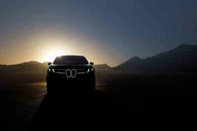 BMW-iX3-auf-Straße-Frontansicht-bei-Sonnenuntergang