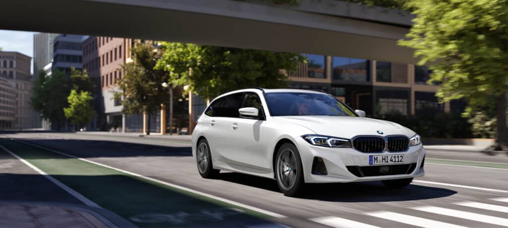 BMW 3er Touring auf Straße vor Zebrastreifen - fährt unter einer Brücke durch