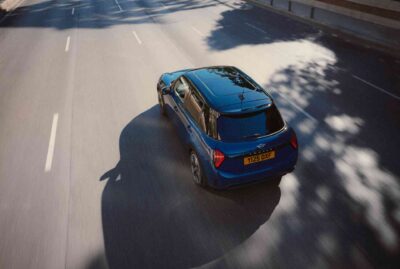 MINI Cooper 5-Türer in dunkelblau auf einer Straße von schräg hinten und oben fotografiert