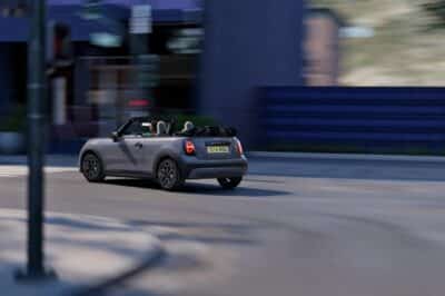 MINI Cooper Cabrio mit offenem Verdeck in grau in Kurve