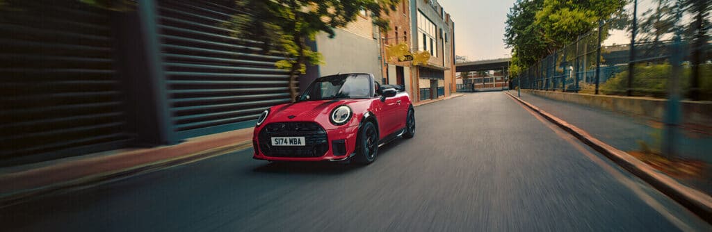 Rotes MINI Cooper Cabrio auf Straße.