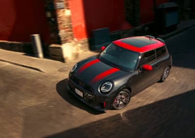 MINI John Cooper Works 3 Türer Hatch in schwarz mit roten Spiegelkappen, rotem Dach mit Schiebedach und roten Motorhaubenstreifen von schräg oben vorne