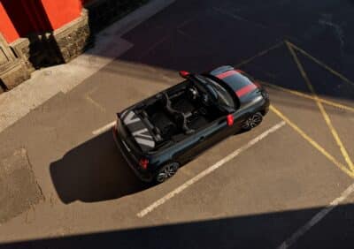 MINI John Cooper Works Cabrio mit roten Spiegelkappen und Motorhaubenstreifen - Blick von oben mit geöffnetem Dach