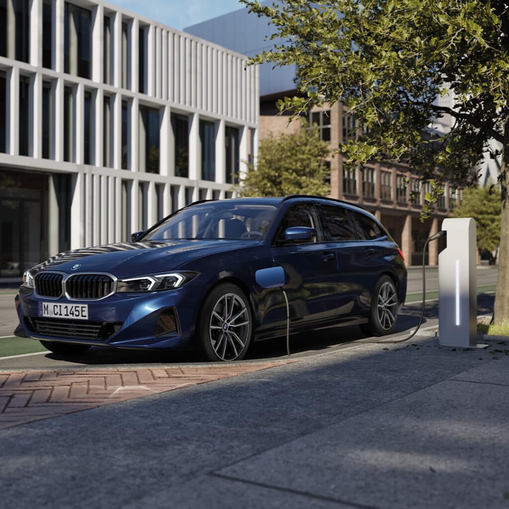 BMW 3er Touring Plug-in-Hybrid in Seitenansicht vor urbaner Kulisse