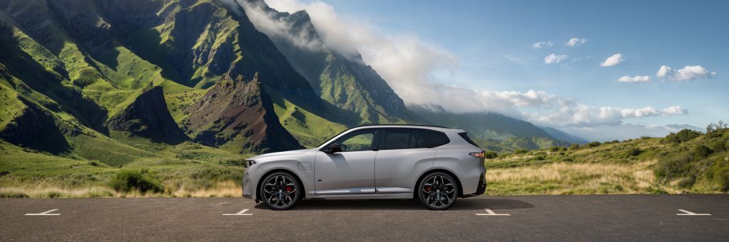neuer BMW X5 silber vor Bergpanorama seitliche Ansicht