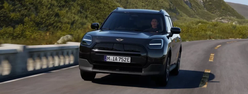 MINI Countryman Blackyard in fahrender Bewegung auf Landstraße von vorne.