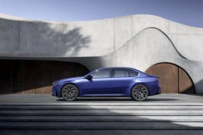 Autohaus Unterberger BMW i3 Limousine in blau von der Seite vor einem modernen Gebäude