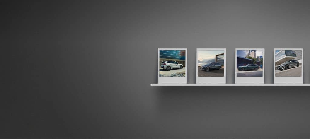 BMW Premium Selection - graue Wand mit Bilderleiste auf der Bilder von BMW Fahrzeugen stehen
