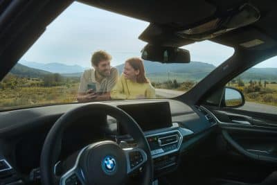 Repair Inclusive Kunden stehen relaxed an ihrem BMW iX3