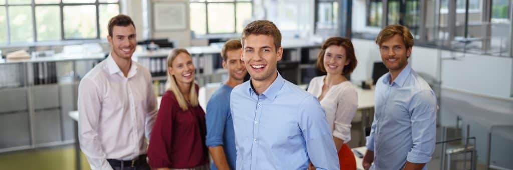 Unterberger Karriere Header - 4 junge Männer und zwei junge Frauen stehen in einem Büro und schauen lächelnd in die Kamera